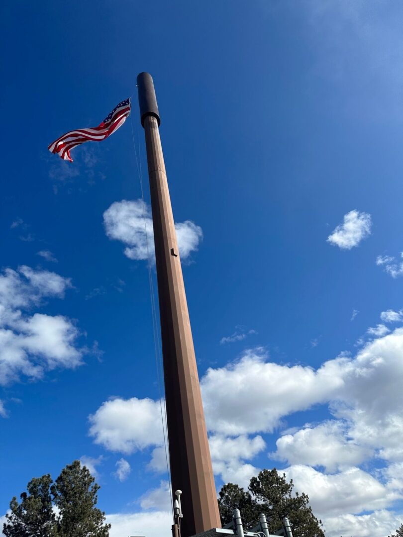 A flag flying on top of a wooden pole.